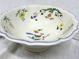 a bowl and a plate with a bird on it on a table