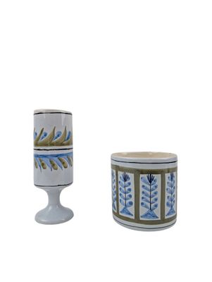 pair of white and blue vases with designs on them on a white background