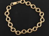 un bracelet en chaîne dorée orné d'un pendentif en forme de cœur sur fond noir