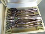 six forks in a box with a spoon in it