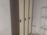 a closet in the corner of a room with a book shelf