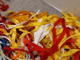 a pile of colorful ribbons on the floor next to a pair of scissors