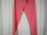 a pair of pink pants hanging on a hanger in front of a white curtain