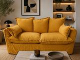 a yellow couch sitting in a living room next to a coffee table