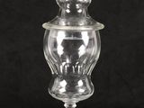 a clear glass jar with a lid on a black background