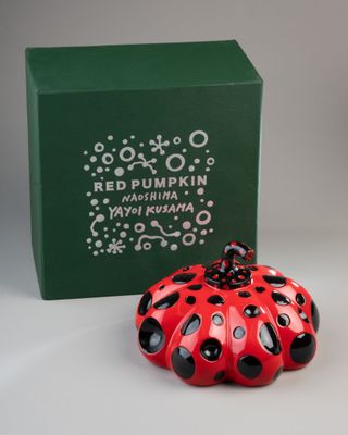 a small red and black ladybug figurine next to a green box