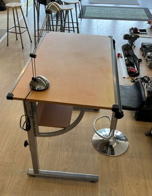 un bureau sur lequel est posée une lampe, au milieu d'une pièce