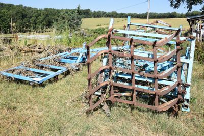 a blue plow that is sitting in the grass