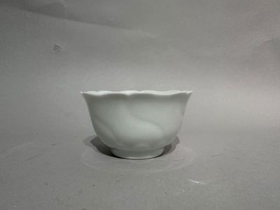 a white bowl sitting on a table with a white background