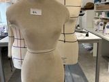 three mannequins on a stand in a sewing room