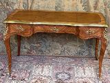 a wooden table with a gold top on a rug