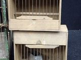 two small wooden cages with a bird inside of them