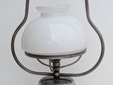 a small white lamp hanging from a metal pole