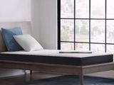 un lit avec un matelas, placé devant une fenêtre