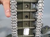 a person holding a toy tank with a chain attached to it