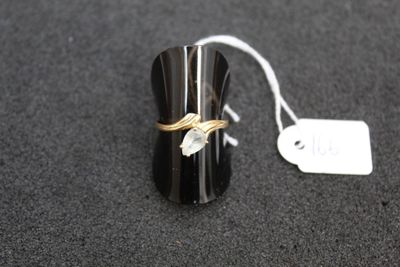 a black and gold ring on a black surface with a price tag