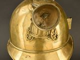 brass helmet on a black stand with a black background