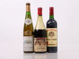 trois bouteilles de vin sont alignées sur une surface blanche