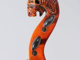 a close up of a violin with a dragon head on the back of it
