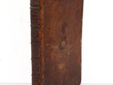 an old book sitting on top of a table next to a white wall