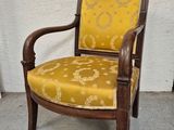 une vieille chaise dont l'assise est recouverte d'un tissu jaune