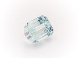 a close up of a green and white diamond on a white surface