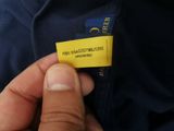 a person holding a yellow label on a blue shirt