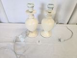 two white vases sitting on a table with wires attached to them