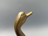 a gold statue of a bird with a diamond in its beak