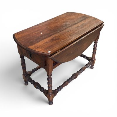 une vieille table en bois aux pieds tournés et au plateau rabattable
