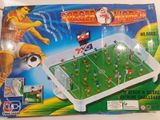 jeu de football miniature dans une boîte en plastique posé sur un plateau de table blanc