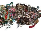 a pile of assorted jewelry on a white surface