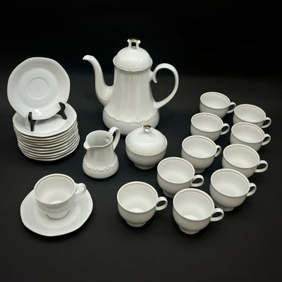 une photo d'un service à thé blanc avec des tasses et des soucoupes