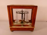 a small wooden clock with a pendulum on it