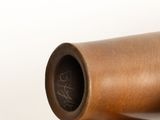 a brown vase sitting on top of a white table