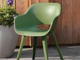 une chaise verte posée à côté d'une plante en pot sur une terrasse