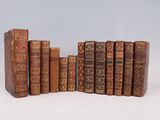plusieurs vieux livres sont alignés sur une surface blanche