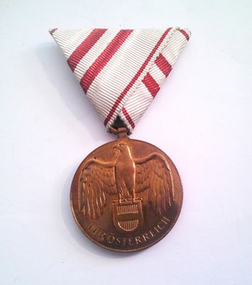 a medal on a white table with a red and white ribbon