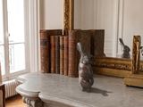une statue représentant un lapin assis sur une cheminée