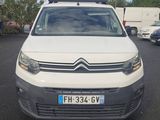 la camionnette blanche est garée dans un parking avec d'autres voitures