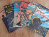 four books on a wooden table, one of which has a picture of a man in a helmet and the other of which is a man in a helmet