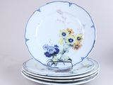 quatre assiettes empilées les unes sur les autres, ornées de fleurs