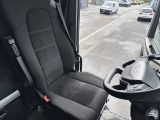 a black seat in the driver ' s seat of a bus
