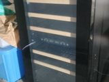 a wine cooler sitting on the sidewalk next to a box of soda