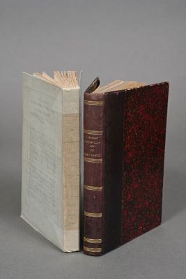two books sitting side by side on a table with a gray background