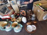 un homme debout devant une table couverte d'objets