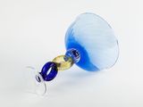 a blue and gold wine glass on a white table
