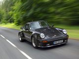 blurry photograph of a black sports car driving down a country road