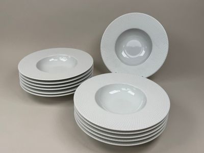 quatre assiettes blanches empilées les unes sur les autres sur une table