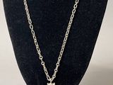 collier en métal argenté avec un pendentif en émail marron et blanc